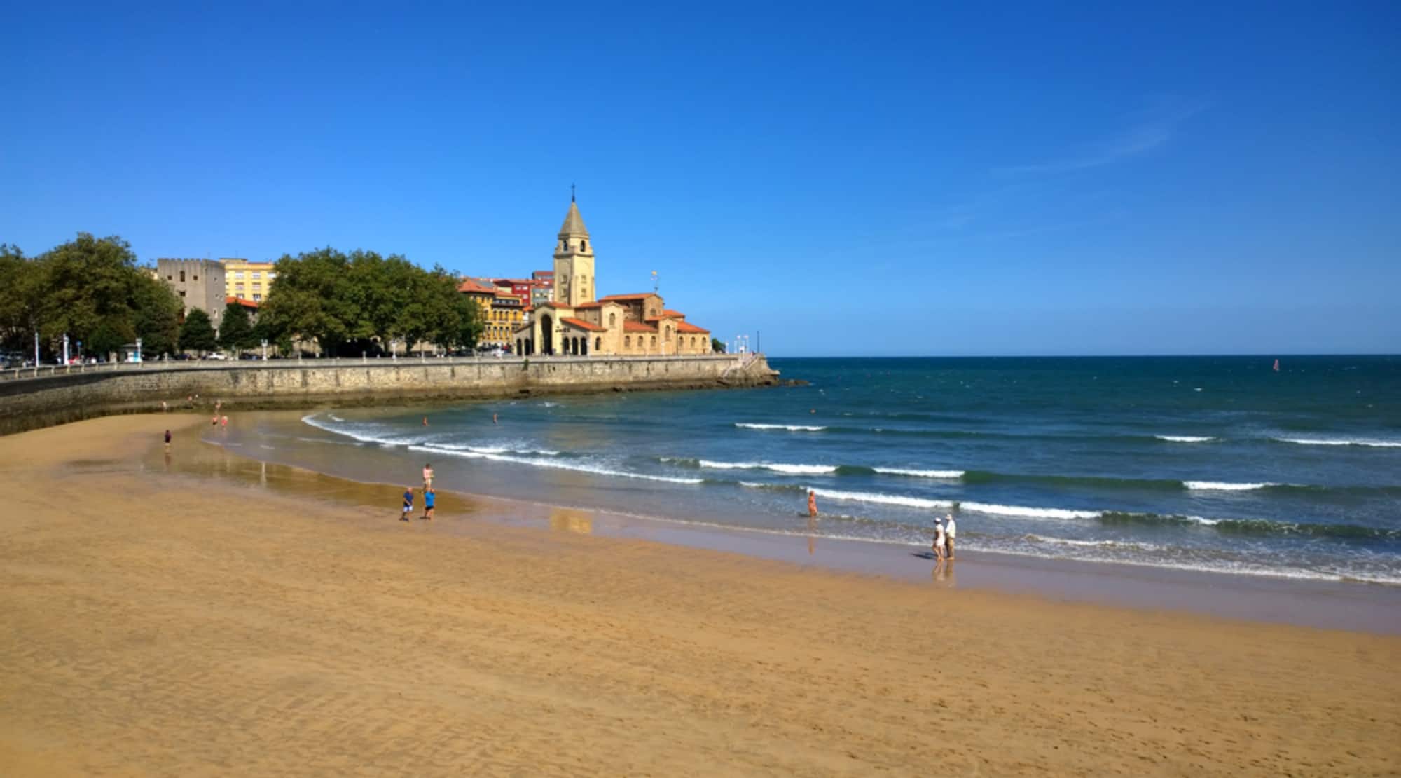 Panorámica de la costa de la playa urbana de Gijón en que transcurre el libro, con marea baja.