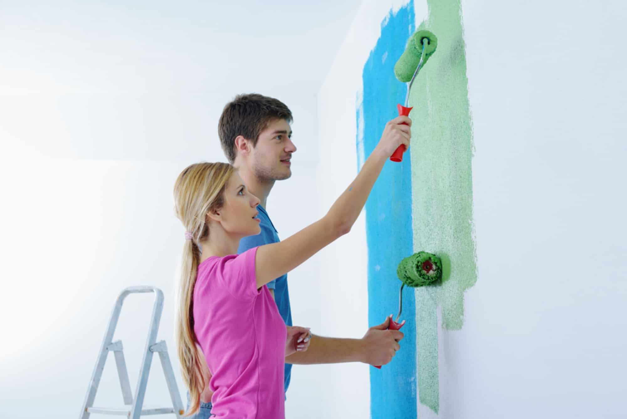 Una pareja pinta las paredes de su casa para darle un nuevo estilo a su vivienda.